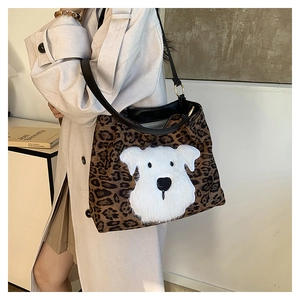Detailed view of leopard print tote bag with plush puppy embroidery and black leather straps
