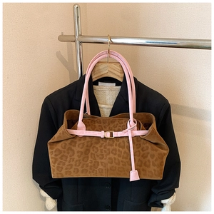 Détail du cabas léopard avec sangle en cuir rose et boucle métallique élégante