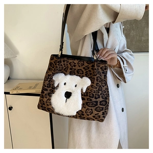 Detailed close-up of leopard print tote bag featuring a white cartoon dog patch and gold metal clips