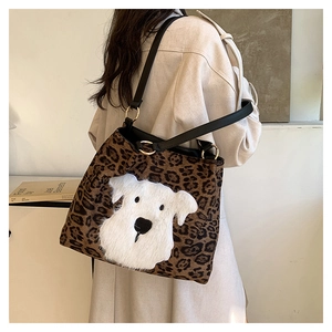 Detailed view of leopard print tote bag with white plush dog patch and gold hardware