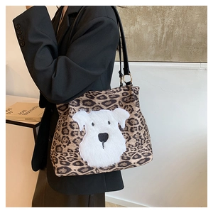 Detailed view of leopard print tote bag featuring a plush cartoon dog patch and gold rings
