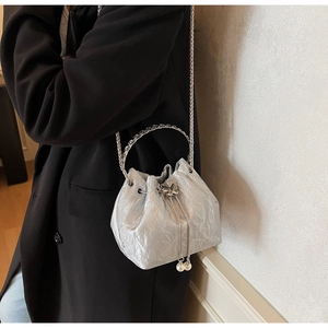 Détail du sac seau argenté avec plis métallisés, perles et fine bandoulière chaîne