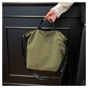 Olive green nylon tote bag with black straps and detachable small zip pouch detail