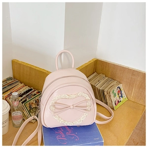Détail de la dentelle en cœur et du nœud sur le petit sac à dos en similicuir rose