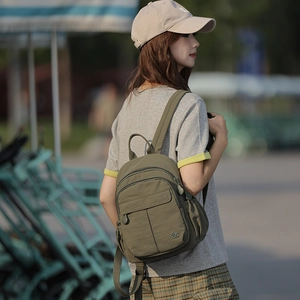 Détail d'un sac à dos de voyage en nylon vert armée avec rangements et logo en métal