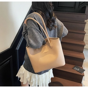 Sac fourre-tout beige avec texture grainée porté à l'épaule pour le travail