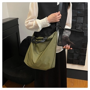 Army green nylon tote bag with black mesh organizer pouch in a modern lifestyle setting