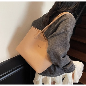 Gros plan d'un grand sac cabas beige avec texture en cuir grainé et longues bandoulières