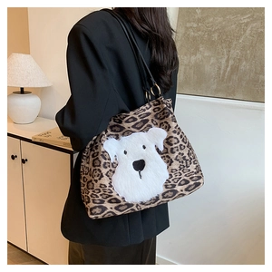 Detail of leopard print tote bag with white plush dog patch and black leather strap