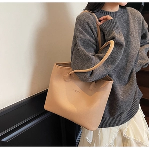Gros plan d'un sac cabas en cuir beige avec lettrage Fashion Trend porté par un mannequin