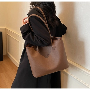 Détail du sac cabas marron foncé avec texture cuir grainé et logo gaufré élégant
