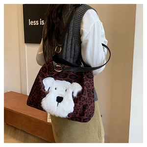 Leopard print tote bag detail showing plush dog embroidery and leather straps