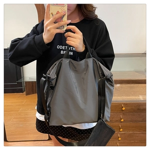 Detail of dark grey nylon tote bag with wide strap and matching mesh coin purse