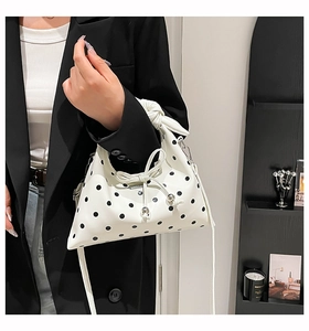 Close-up of retro polka dot crossbody bag with drawstring bow and metal bead detail