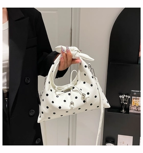Close-up of retro black polka dot handbag with bohemian knot handle and silver hardware