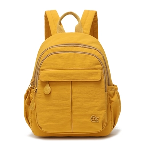 Détail frontal du sac à dos en nylon jaune vif avec plusieurs poches et logo circulaire