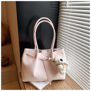Détail du sac cabas rose avec texture tissée et un adorable pendentif ours en peluche