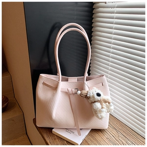 Détail du sac cabas rose clair tissé avec boucle chic et pendentif ours mignon