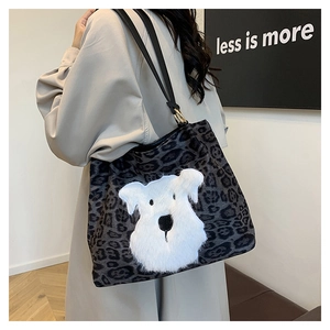 Detail of grey leopard print tote bag with plush schnauzer dog patch and black leather straps