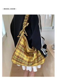 Detail of yellow plaid tote bag featuring pleated shoulder strap and decorative bow knot