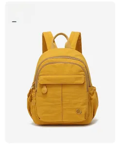 Détail d'un sac à dos en nylon jaune avec tissu imperméable et poches zippées
