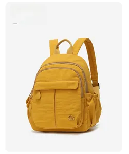 Vue latérale détaillée d'un sac à dos jaune en nylon avec plusieurs poches zippées