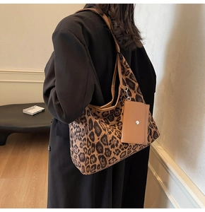 Detail view of large leopard print tote bag with brown straps and matching mini pouch