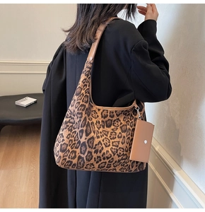 Detail of leopard print tote bag with brown leather strap and small matching pouch