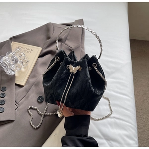 Détail du sac seau plissé noir avec boucle papillon argentée et breloque perle