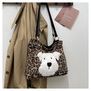 Close-up of leopard print tote bag with fluffy white dog patch and gold ring hardware