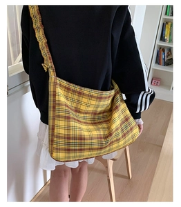 Close-up detail of yellow vintage plaid canvas crossbody bag with wide shoulder strap