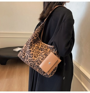 Detailed close-up of leopard print tote bag with brown leather trim and matching pouch