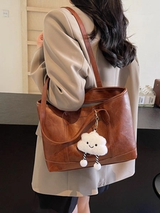 Elegant brown pebble leather tote bag with white cloud plush charm for daily commuting