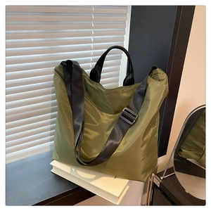 Detail of olive green waterproof nylon tote bag with black adjustable shoulder strap