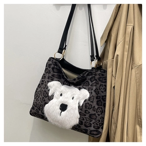 Detailed view of leopard print tote bag featuring a plush dog patch and gold ring hardware