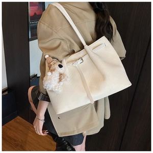 Détail du sac cabas tissé blanc cassé avec boucle argentée et breloque ours en peluche