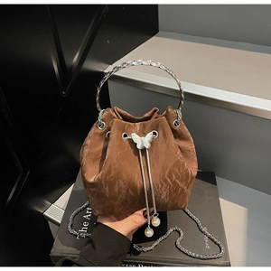 Détails du sac seau marron plissé avec fermoir papillon et pendentif en perles