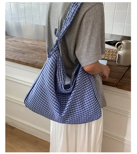 Detail of blue vichy plaid canvas tote bag with adjustable shoulder bow knot design