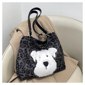 Detail of leopard print tote bag featuring a plush puppy patch and golden hardware