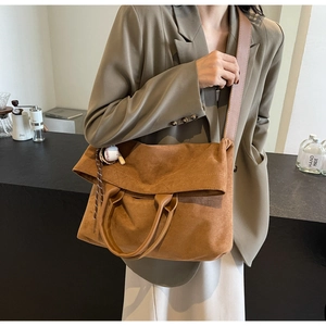 Vue détaillée du grand sac cabas en daim marron avec pendentif baseball et bandoulière