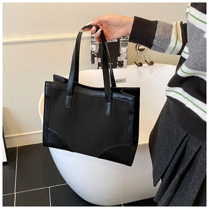 Détail du sac cabas noir en toile et cuir avec coins renforcés pour le trajet quotidien