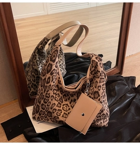 Detail of leopard print tote bag with attached beige zipper pouch on satin fabric