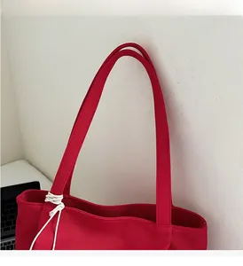 Close-up of durable reinforced wide handle and stitching on red canvas tote bag