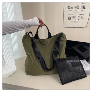Olive green nylon tote bag detail with detachable shoulder strap and black mesh pouch