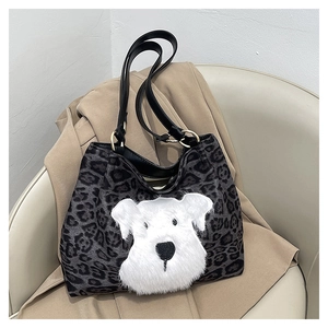 Detail of grey leopard print tote bag with plush dog patch and black leather handle
