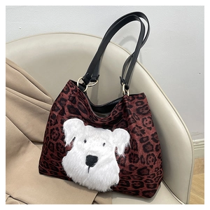 Close-up of leopard print tote bag featuring plush cartoon dog patch and gold hardware