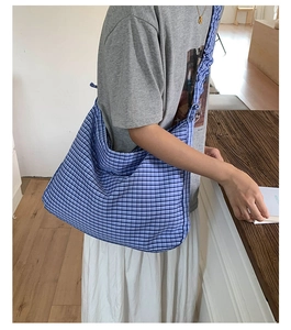 Detail of blue and white plaid tote bag showing its large capacity and soft fabric texture