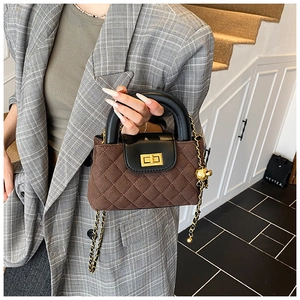 Detail of vintage brown quilted suede handbag with gold turn-lock and chain strap