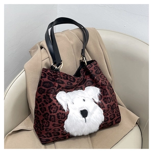 Close-up of leopard print tote bag with white schnauzer plush patch and leather handles