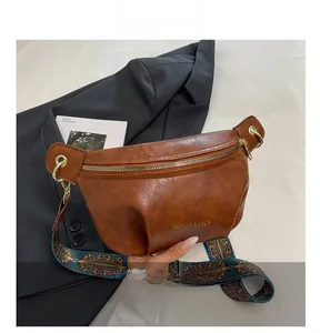 Detail of vintage brown leather dumpling bag with geometric patterned wide strap